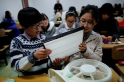 Students learn how to make the do-it-yourself (DIY) air purifier at a college in Beijing, in a workshop sponsored by a company that invented the DIY air filter.