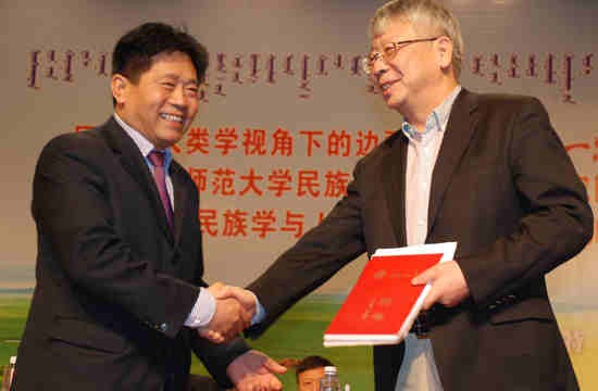 Inner Mongolia Normal University President Yun Guohong and Assistant to the President of the Chinese Academy of Social Sciences Hao Shiyuan shake hands during the unveiling ceremony for the school.