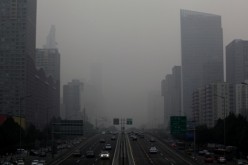 A view of Jianguo Road on a hazy day in Beijing's central business district .