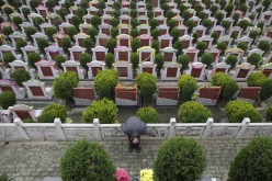 A man bows to the tomb of a relative during the Qingming Festival, or Tomb Sweeping Day, at a public cemetery in Wuhan, Hubei Province, April 5, 2014. 