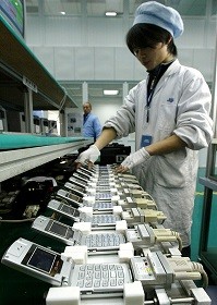 A worker tests mobile phones at a production line of Ningbo Bird Co. Ltd. in the eastern port city of Ningbo.