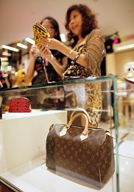 A shopper in a Louis Vuitton store during Vogue's 4th Fashion's Night Out in downtown Shanghai in 2012.