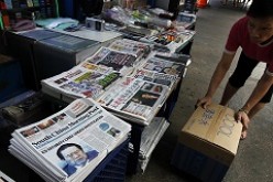 A vendor selling newspaper at a newsstand in Hong Kong.