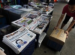 A vendor selling newspaper at a newsstand in Hong Kong.