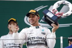 Mercedes Formula One driver Lewis Hamilton of Britain (R) gestures with his trophy as he celebrates his victory after winning the recent Chinese F1 Grand Prix at the Shanghai International Circuit.