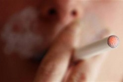A woman smokes an e-cigarette.