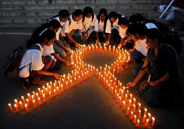 Staff members of a government-run pharmaceutical college light candles