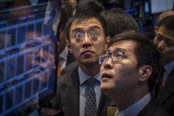 58.com CEO Jinbo Yao (R), watches as his company is priced during its IPO at the New York Stock Exchange. 