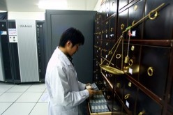 A Chinese scientist looks at stored data tapes located adjacent to a supercomputer at the Beijing Genomics Institute in Beijing.