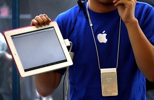 An Apple store employee shows how to use the new iPad 2 during the China launch at an Apple Store in central Beijing.
