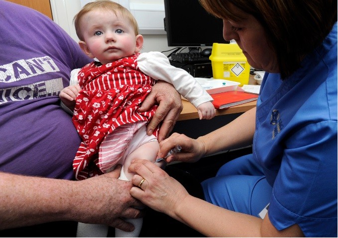 A child is given an MMR injection