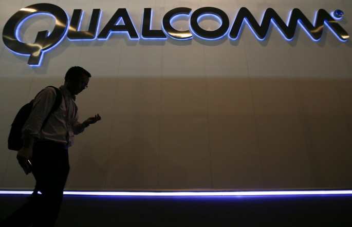 Man walks past Qualcomm stand while attending the Mobile World Congress in Barcelona March 3, 2015. Ninety thousand executives, marketers and reporters gather in Barcelona this week for the telecom op