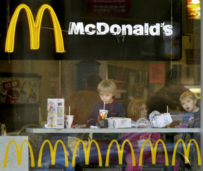 Children peer out the window while eating hamburgers in a Chicago McDonald's restaurant, December 26, 2003.