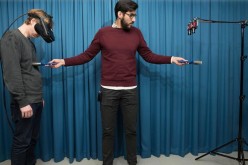 Study co-author Zakaryah Abdulkarim (right) uses a paintbrush to convince a volunteer of his invisibility.