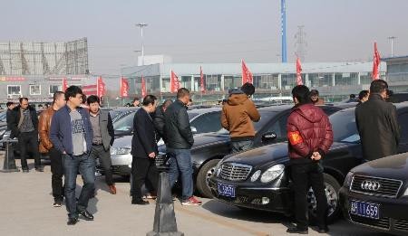 Visitors look at the second batch of to-be-auctioned government vehicles at a preview exhibition in Beijing, March 15, 2015.