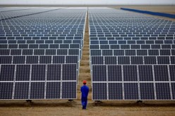 A worker inspects solar panels at a solar farm in Dunhuang, 950 kilometers (590 miles) northwest of Lanzhou, Gansu Province.