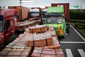 Trucks carrying copper and other goods are seen waiting to enter an area of the Shanghai Free Trade Zone.