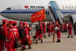 Members of the Chinese International Search and Rescue Team and their rescue dogs board a charted plane to Kathmandu on April 26 to bring aid to quake-hit Nepal.