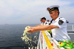 PLA Navy officers scatter flowers into the ocean to commemorate the First Sino-Japanese War, one of the historical events that has caused complicated relationships between Chinese and Japanese.