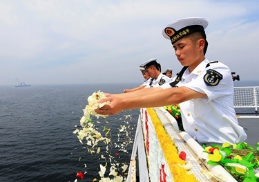 PLA Navy officers scatter flowers into the ocean to commemorate the First Sino-Japanese War, one of the historical events that has caused complicated relationships between Chinese and Japanese.