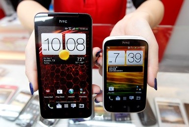 A mockup of an HTC Butterfly smartphone and a Desire C smartphone are displayed in a mobile phone shop in Taipei.