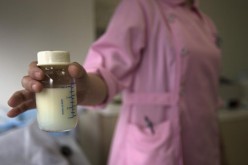 A nurse at Guangzhou Women and Children's Medical Center in southern China presents a donated bottle of breast milk.