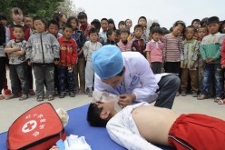 A volunteer from Red Cross Society of China demonstrates CPR to students at a primary school in Shandong Province. 