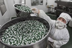 A worker packs Chinese patent capsules in a drug factory in China. 