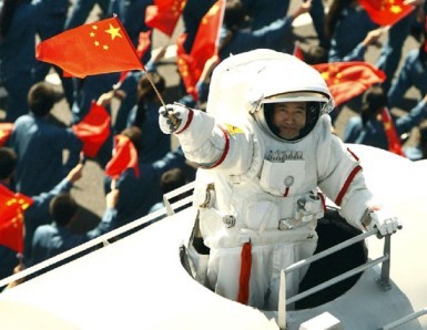 Chinese taikonaut Zhai Zhigang emerges from a simulated Shenzhou-7 capsule and waves a national flag during the celebrations for the 60th anniversary of the founding of the People's Republic of China.