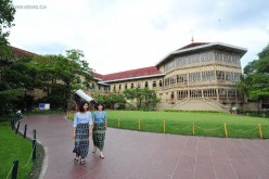 Chinese visitors strolling in front of Vimanmek Mansion, a former royal palace in Bangkok, Thailand.