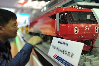 A visitor takes a look at a model locomotive train made by China CNF at an exhibition in Beijing. 