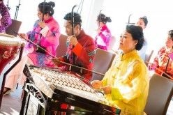 Chinese musicians playing traditional instruments during a performance.