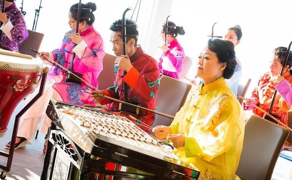 Chinese musicians playing traditional instruments during a performance.