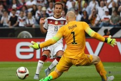 Mario Goetze (L) of Germany attacks Brad Guzan of the U.S.