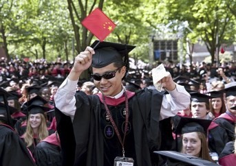 A Chinese student waves the national flag during a graduation ceremony in an American university.
