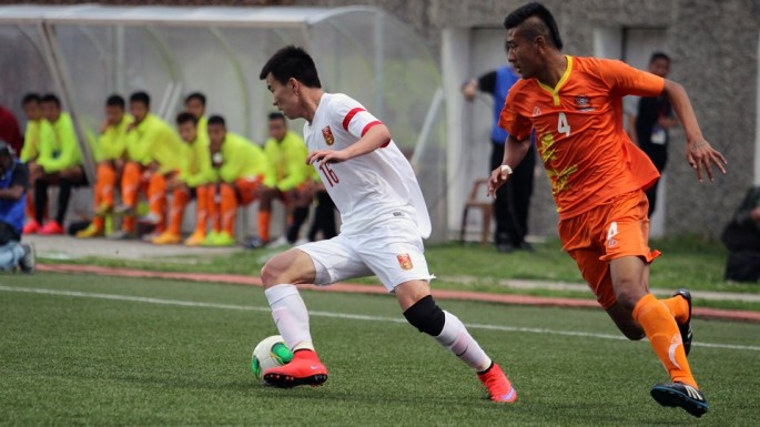 Bhutan's Jigme Tshering Dorji tries to defend against China's Sun Ke (L) during the FIFA World Cup 2018 qualifying match at the Changlimithang Stadium in Thimphu on June 16, 2015. 