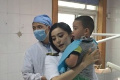Fan Bingbing carries the injured boy who lost some of his teeth to the accident.