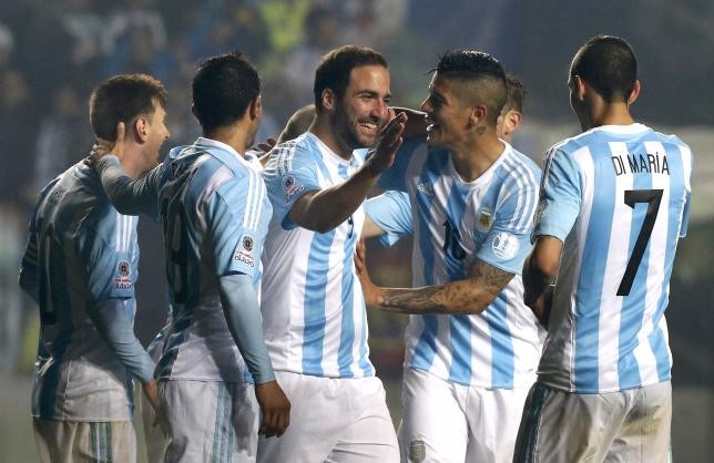 Argentina's Gonzalo Higuain (#9) celebrates with teammates after scoring a goal against Paraguay