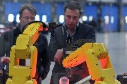 The yellow robot arms dance through an assembly demo for Elon Musk and the rest of the tour group that visited the reopening of the former NUMMI plant, now Tesla Motors.
