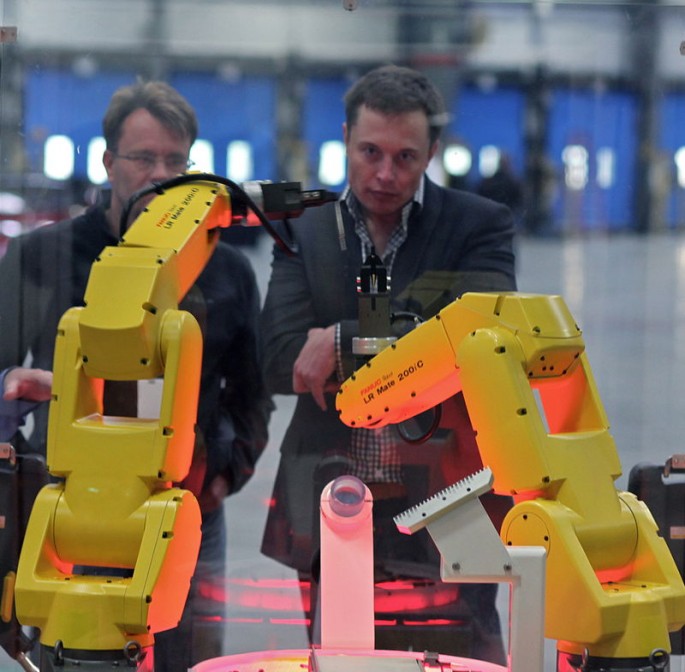 The yellow robot arms dance through an assembly demo for Elon Musk and the rest of the tour group that visited the reopening of the former NUMMI plant, now Tesla Motors.