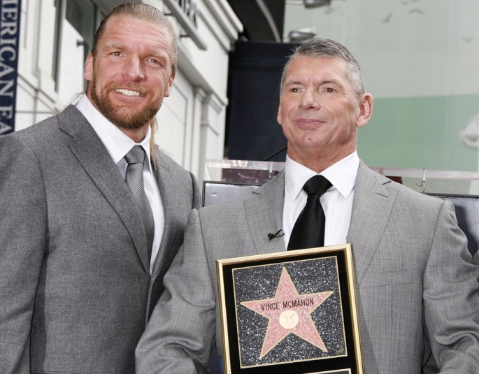Vince McMahon (R), the chairman of World Wrestling Entertainment (WWE), Inc., hold a plaque as he poses with the WWE star Triple H after McMahon's Hollywood Walk of Fame star was unveiled.