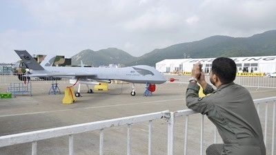 A man takes a picture of the Chinese Wing Loong Unmanned Combat Air Vehicle.