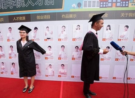 Two of Kunming University's new graduates pose for pictures with the profiles of excellent graduates for the Kunming University Talent Store on Taobao.
