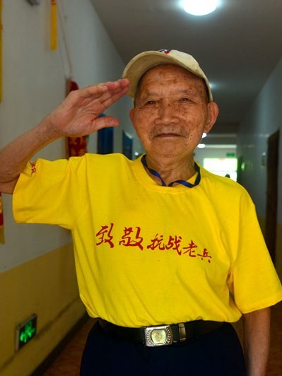 World War II veteran Wang Guangya salutes to the camera.