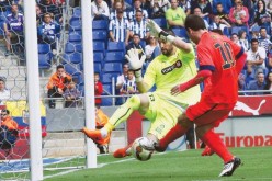 Kiko Casilla attempts to block a shot by Lionel Messi.