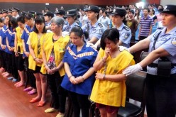Handcuffed child traffickers are presented in court.