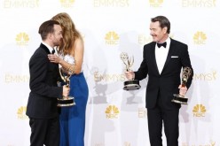 The 66th Primetime Emmy Awards winners Aaron Paul, Anna Gunn and Bryan Cranston pose backstage with their awards for their roles in AMC's 