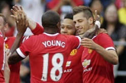 Manchester United's Morgan Schneiderlin (R) celebrates scoring a goal with Ashley Young (#18) and Memphis Depay.