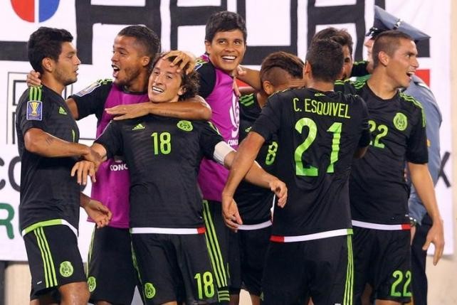 Mexico midfielder Andres Guardado (#18) celebrates with teammates after kicking a penalty kick to score a goal against Costa Rica.