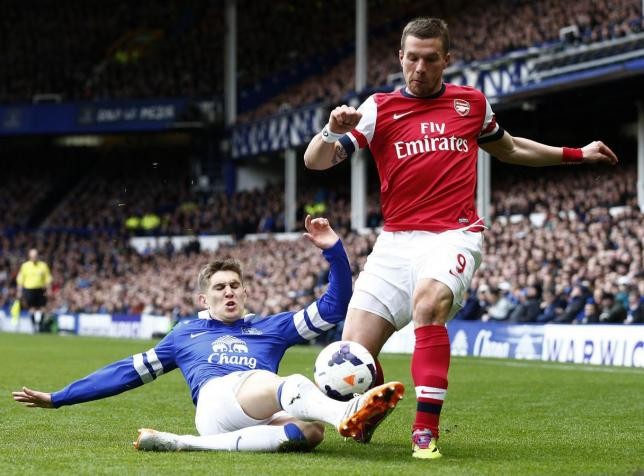 Everton's John Stones (L) challenges Arsenal's Lukas Podolski during their English Premier League soccer match.